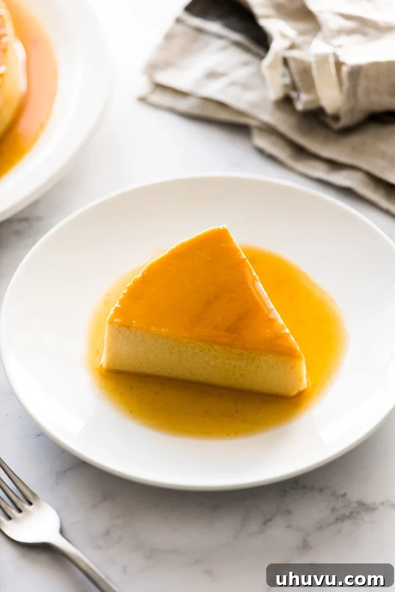 Simple Silky Flan Perfection 9 A beautifully presented flan on a table, with a slice removed to show its smooth texture.
