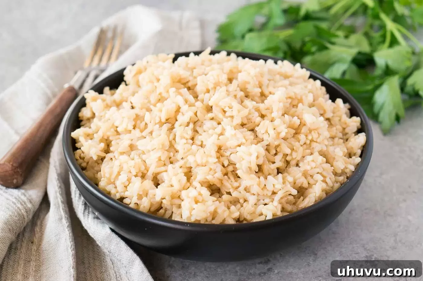 A serving of perfectly cooked Instant Pot brown rice in a black bowl, ready to be enjoyed.