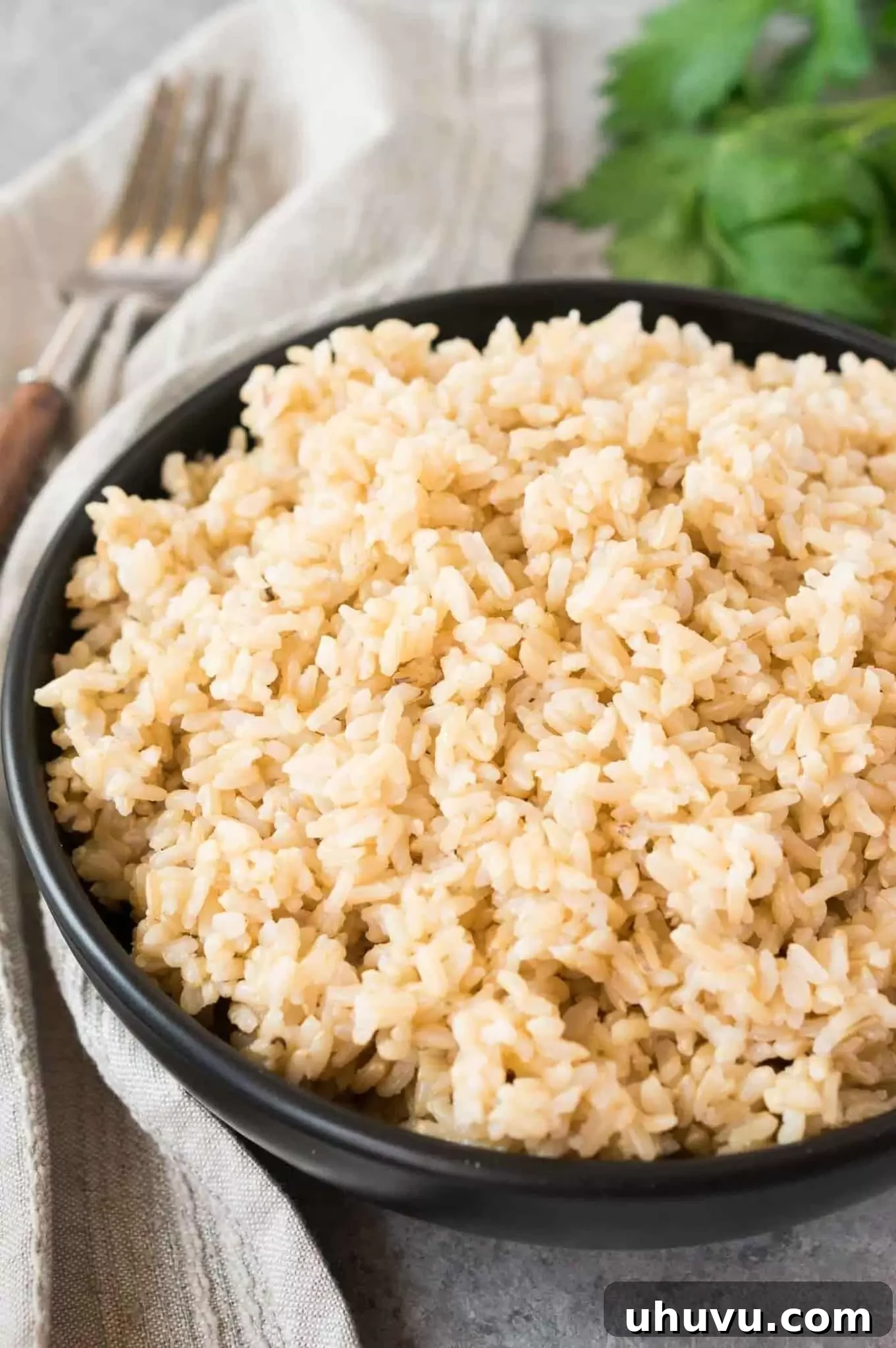 Close-up view of perfectly cooked brown rice, showing individual grains, in a small white bowl.