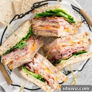 A top-down view of a classic club sandwich with a side of chips, presented on a plate.
