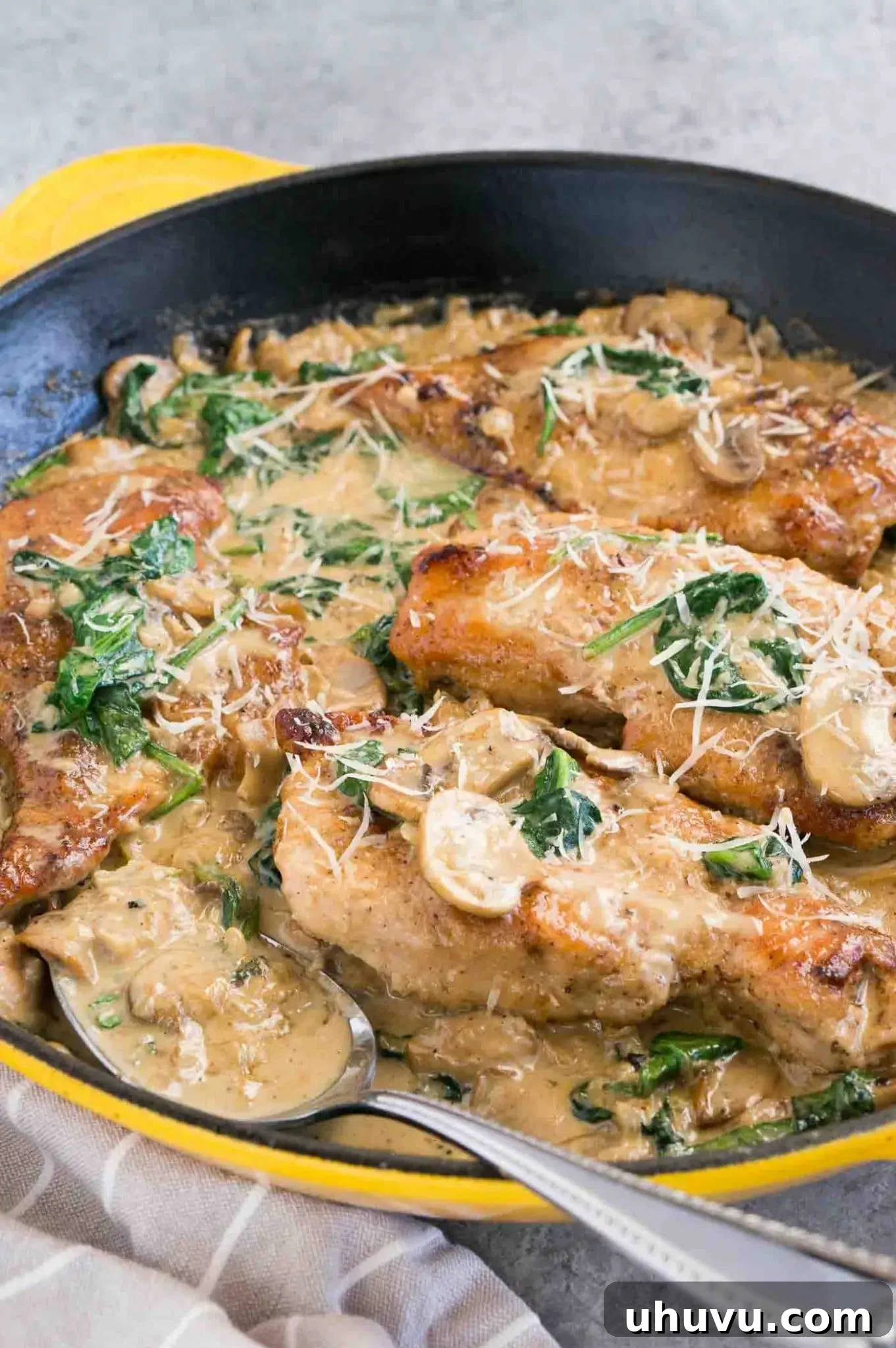 spooning mushroom sauce over chicken