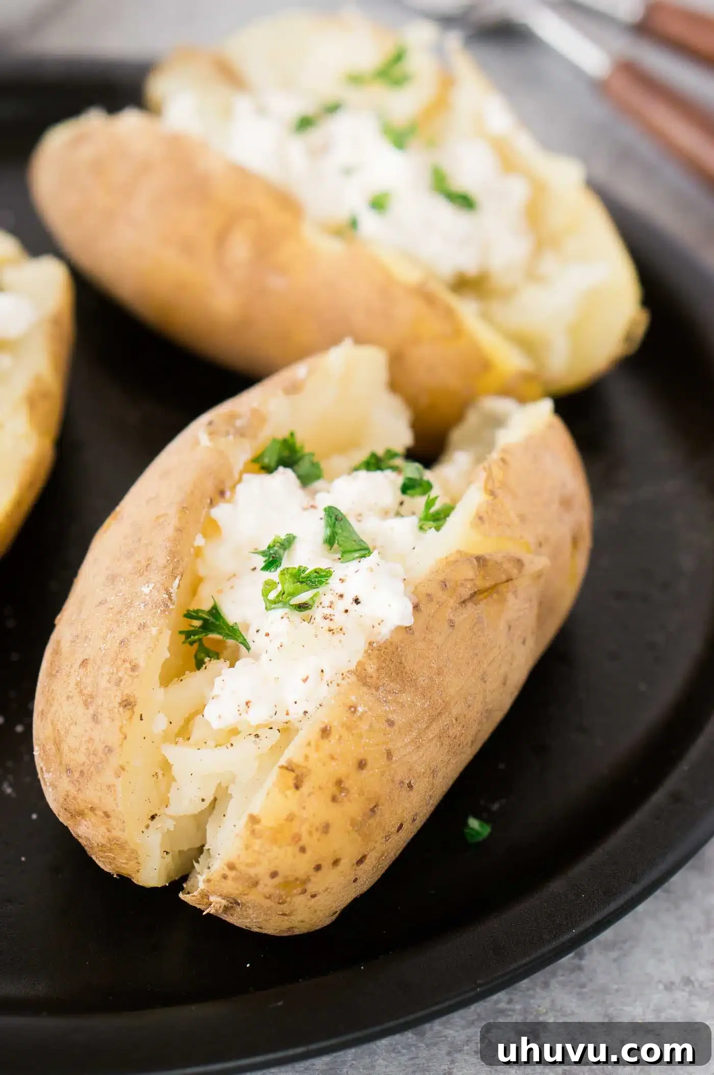 Speedy Instant Pot Baked Potatoes 6 Oven-baked potatoes with sour cream on a plate, ready to be enjoyed