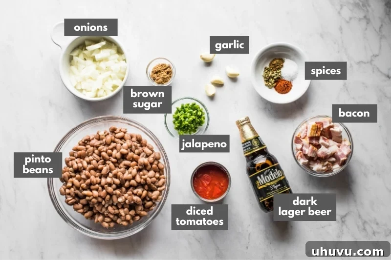 Beer-Braised Fiesta Beans 3 A selection of fresh ingredients including pinto beans, bacon, onions, jalapenos, and spices laid out for making borracho beans.