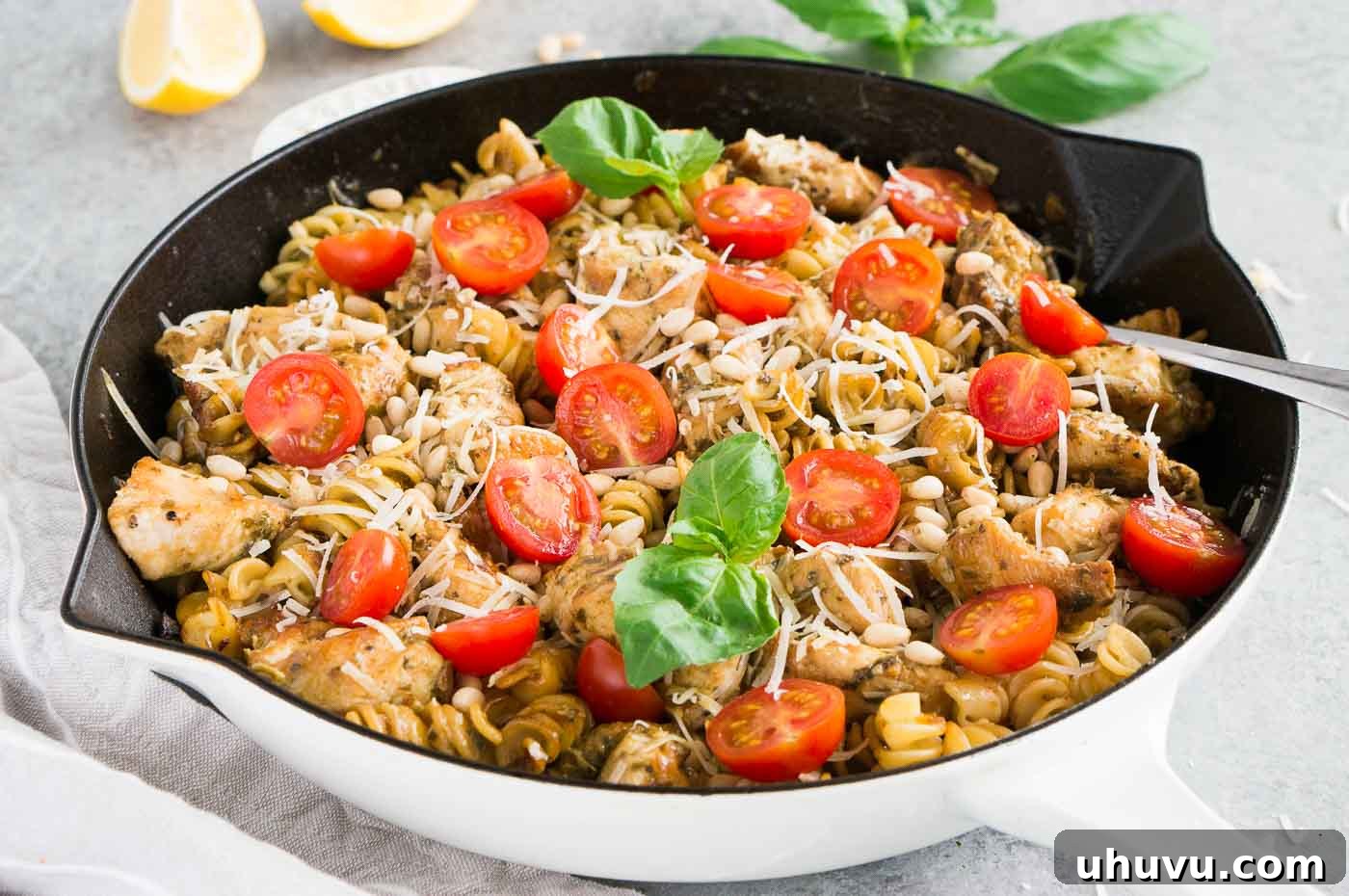 Pesto pasta and chicken cooking in a skillet
