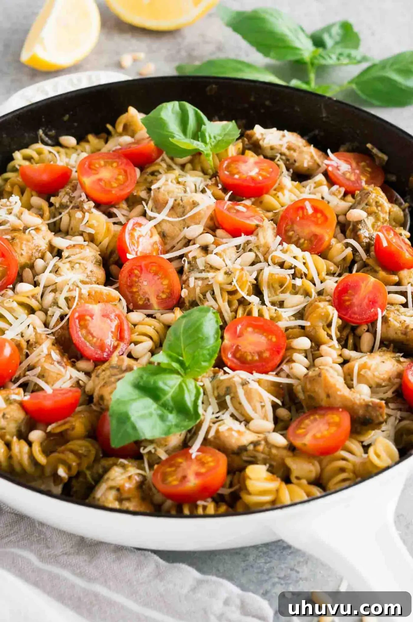 Pesto chicken pasta dish with fresh tomatoes and herbs