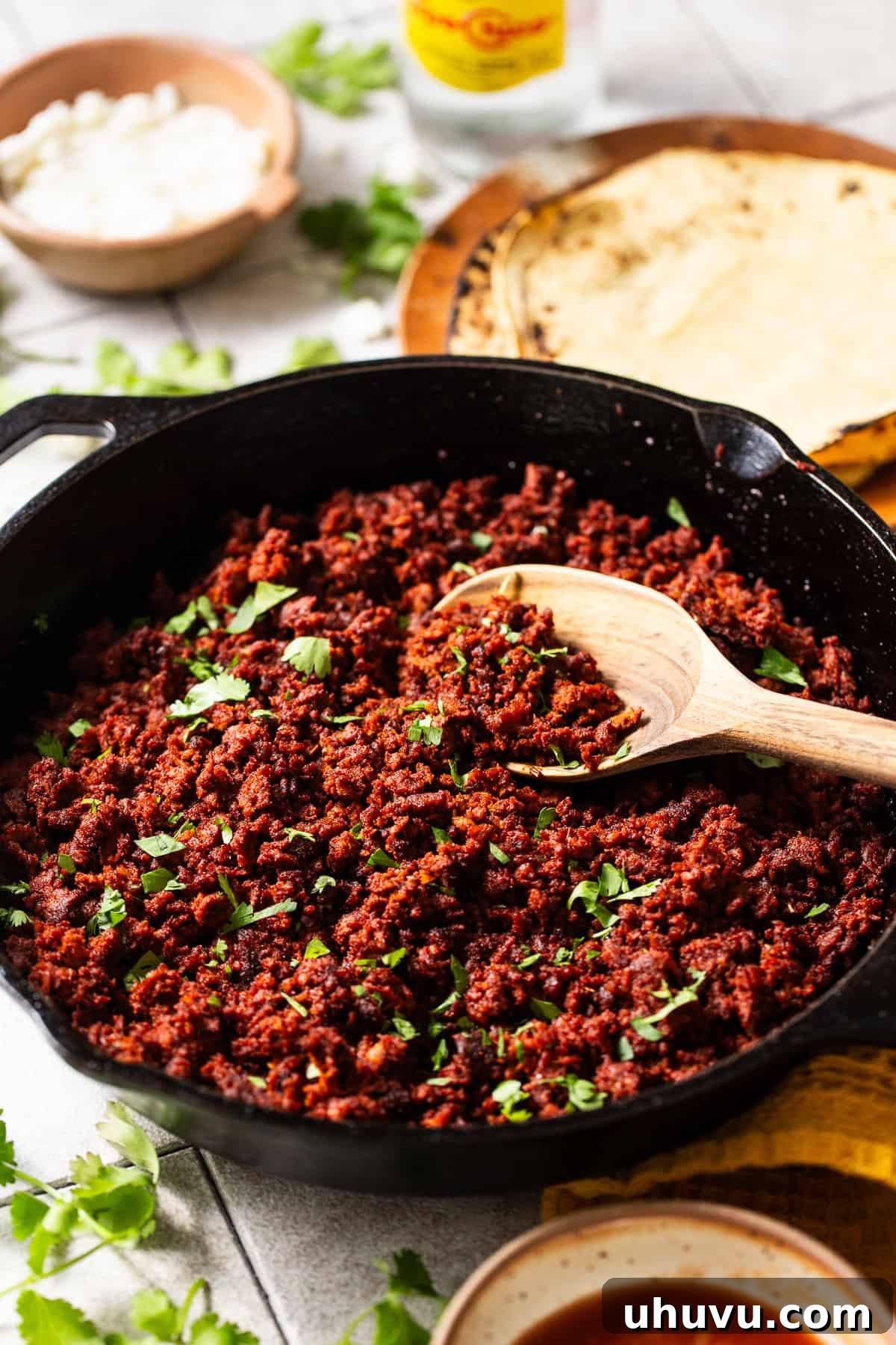 Seasoned Mexican chorizo in a skillet garnished with cilantro, ready to be enjoyed in various Mexican recipes.