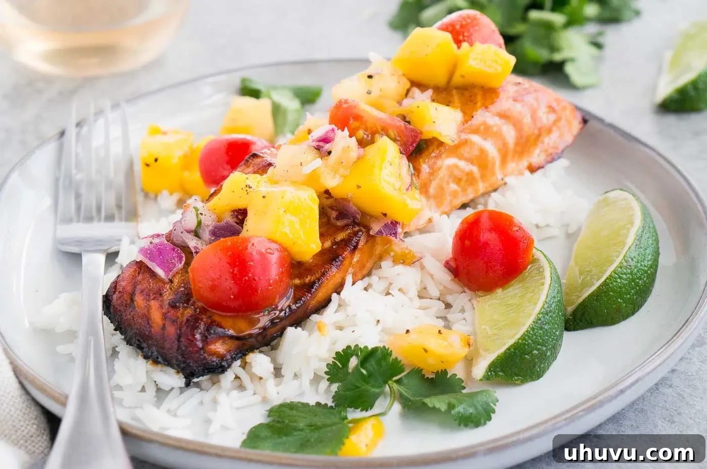 Close-up image of honey baked salmon with salsa on rice
