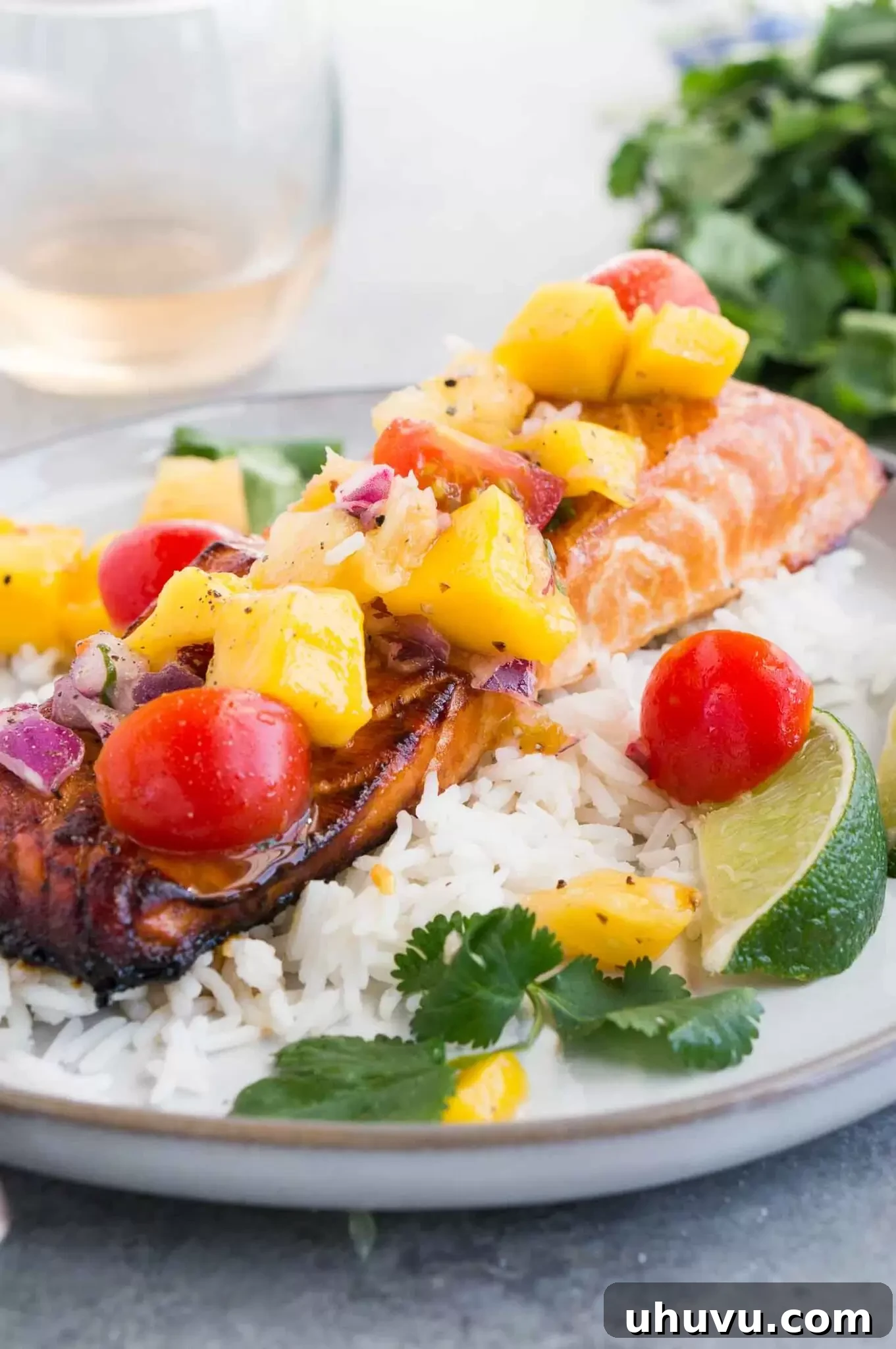 Close-up image of honey salmon with mango salsa over rice