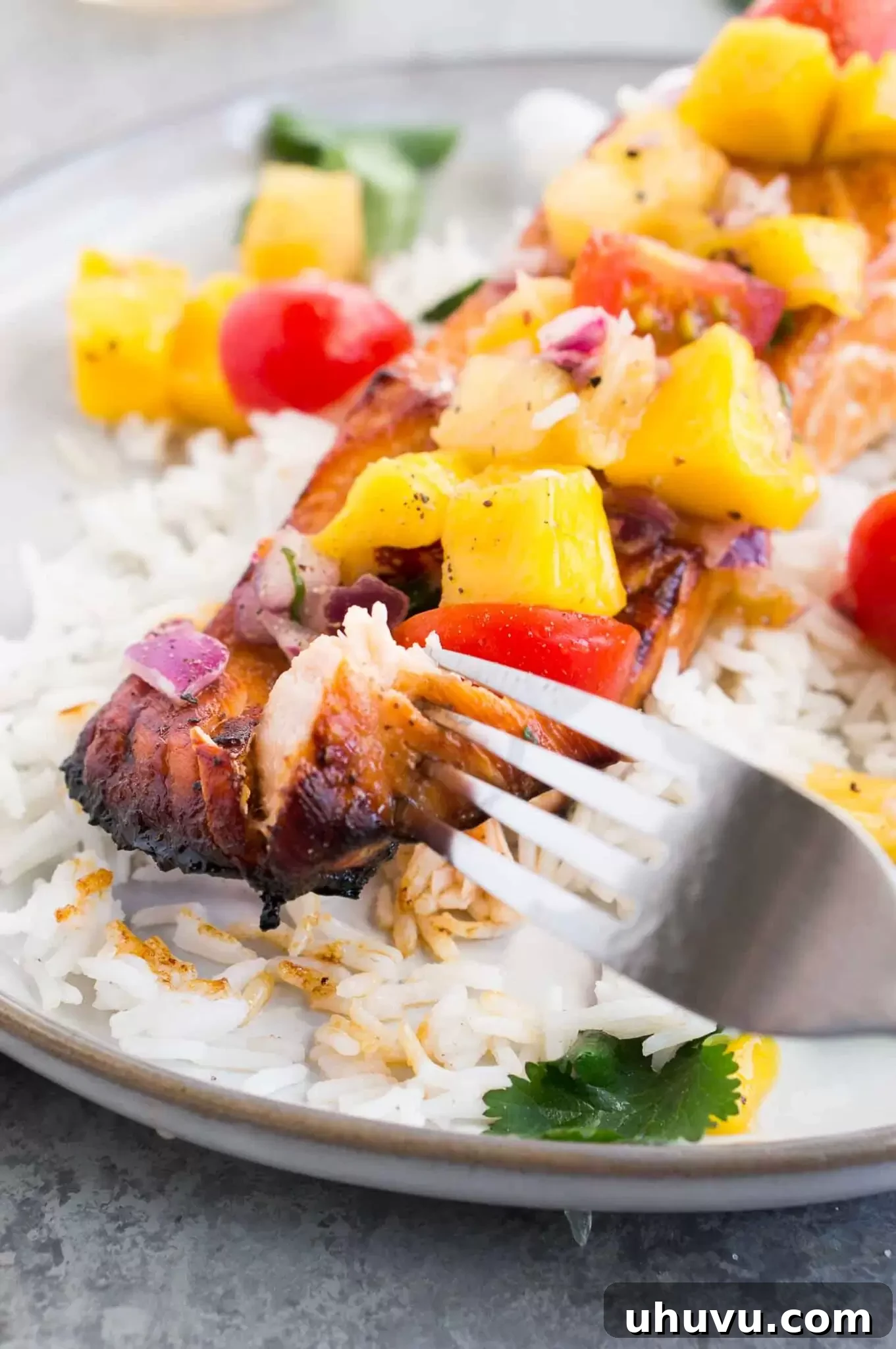 A bite of salmon with fruit salsa