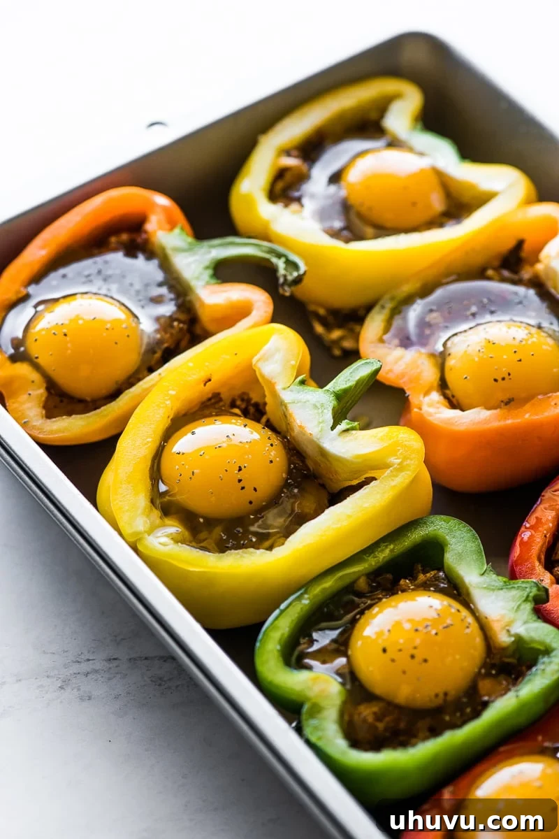 Sunrise Stuffed Peppers 6 Raw eggs carefully cracked into bell pepper halves filled with a chorizo mixture, ready for baking.
