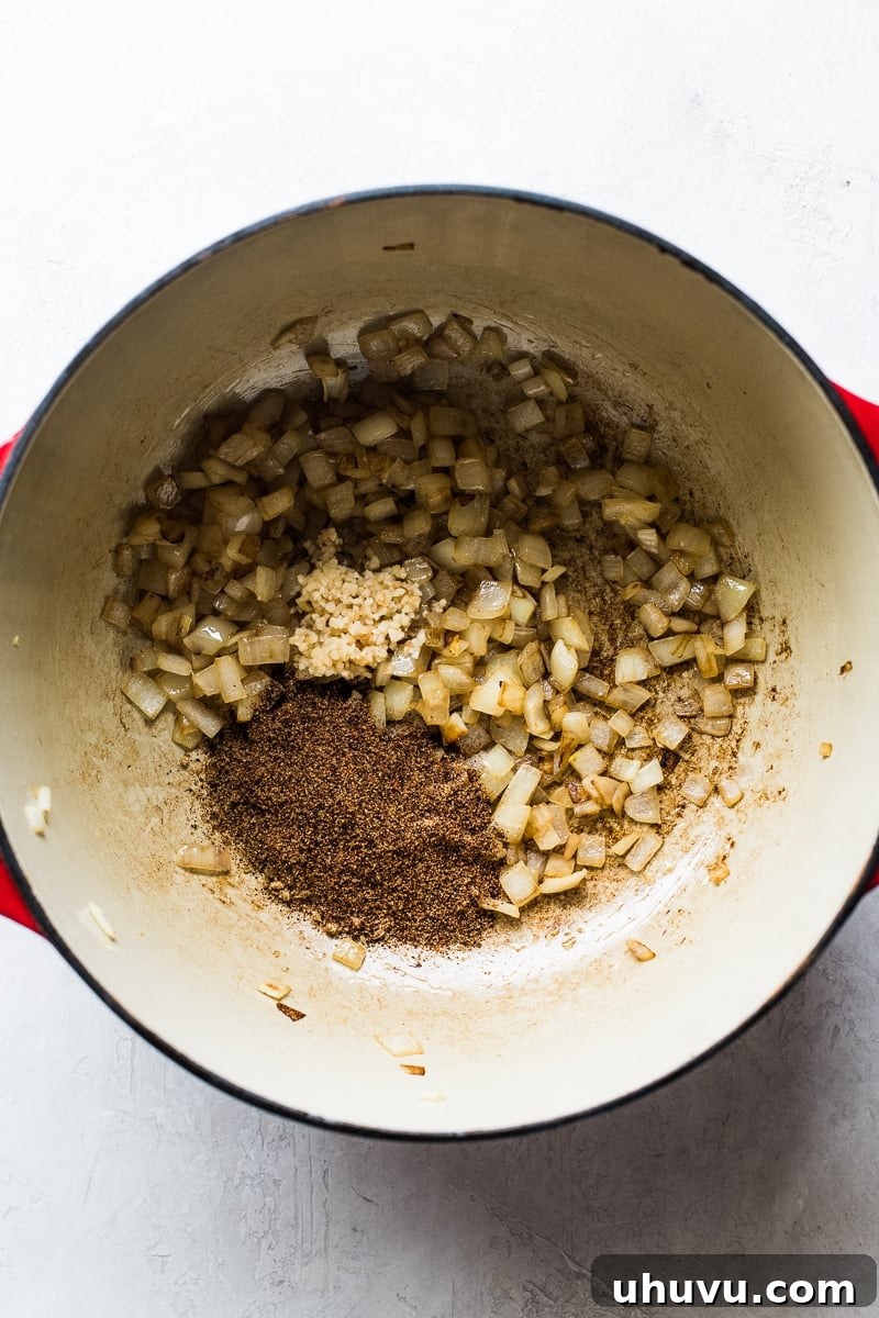 Quick Comfort Pinto Bean Soup 3 Onions, garlic and seasoning in a pot for pinto bean soup.