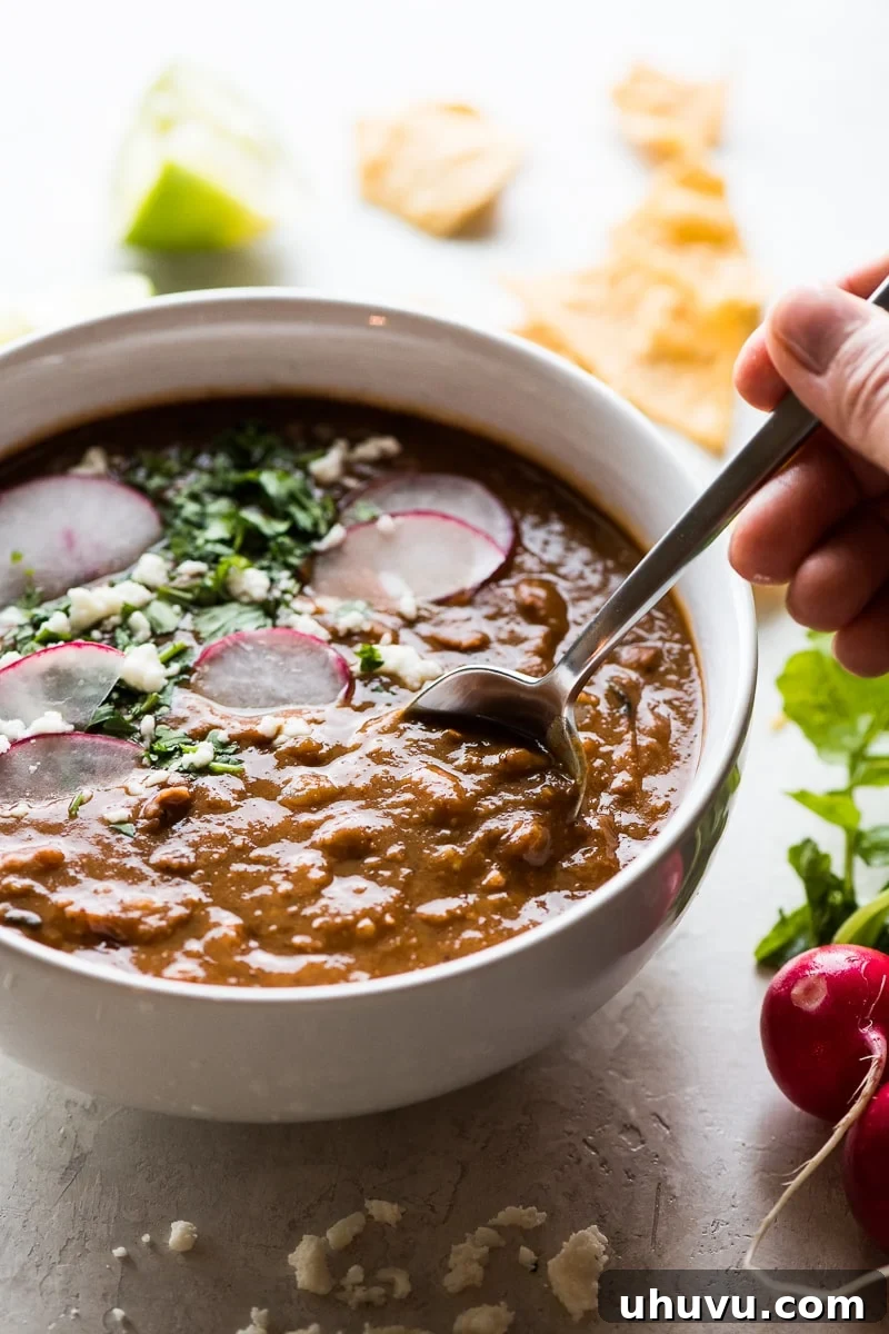 Quick Comfort Pinto Bean Soup 7 A hand grabbing a spoonful of pinto bean soup