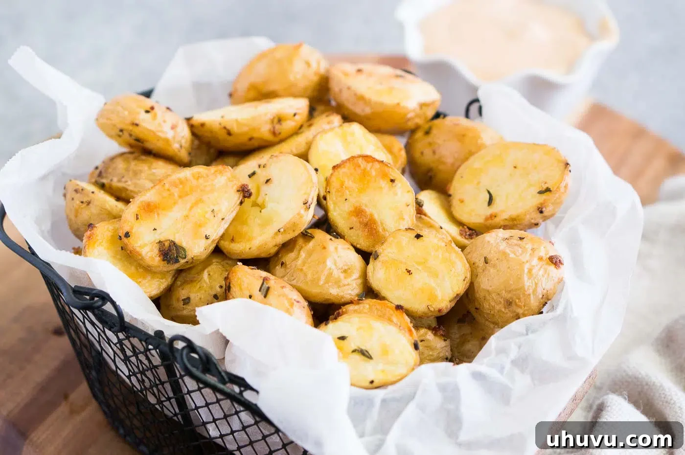 A close-up view of beautifully roasted baby potatoes nestled in a basket, showcasing their golden-brown and crispy texture.
