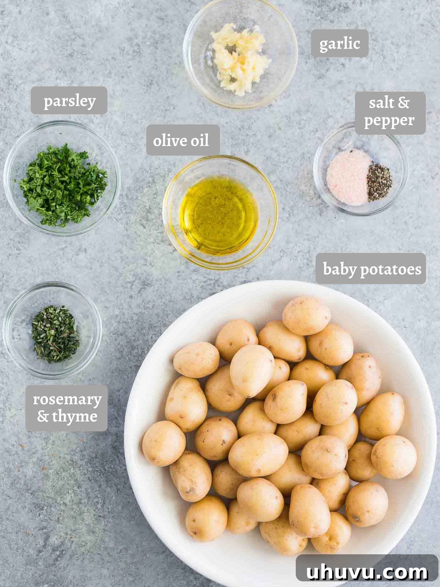 Golden Herb Roasted Baby Potatoes 4 A visual display of all the fresh ingredients required to make delicious roasted baby potatoes, including whole and halved potatoes, fresh herbs, and garlic.