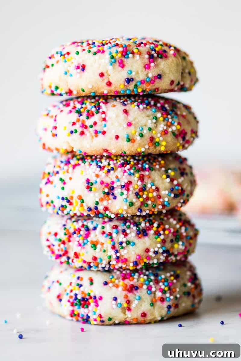 Effortless Funfetti Cookies 2 Sprinkle cookies stacked on top of one another.