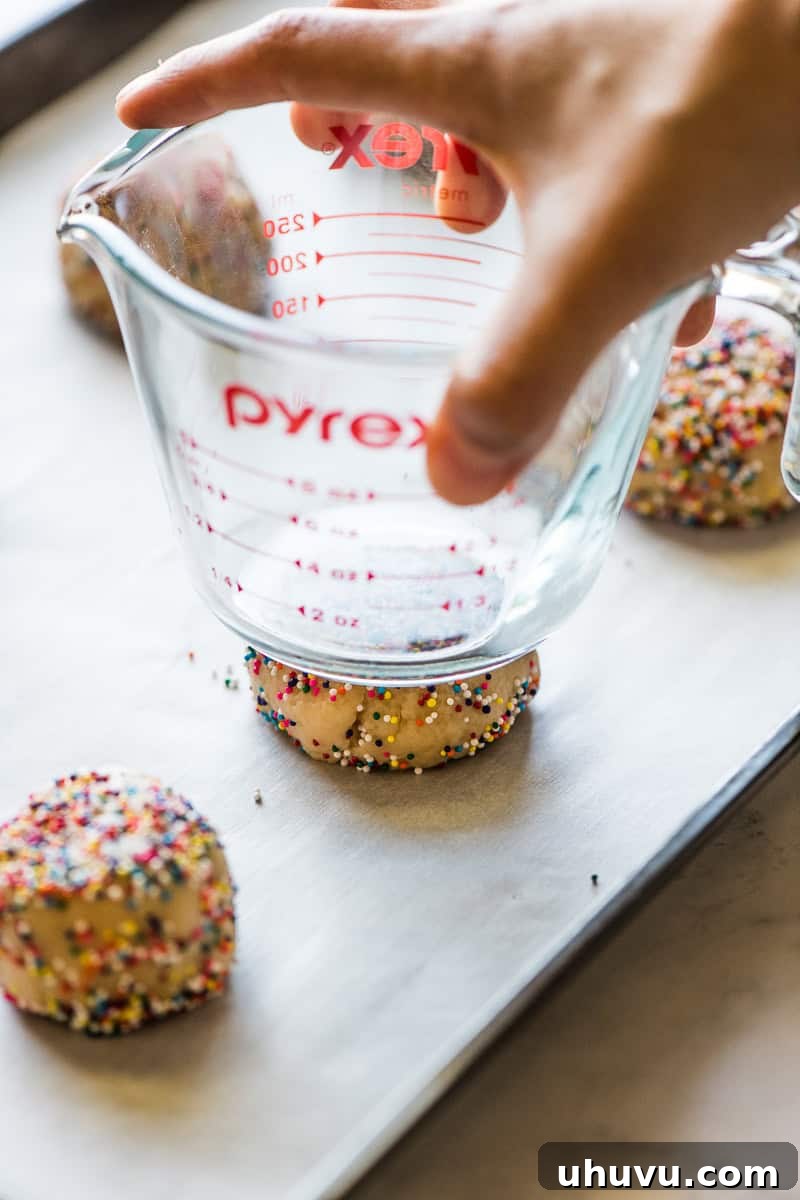 Effortless Funfetti Cookies 4 A sprinkle cookie dough ball being flattened