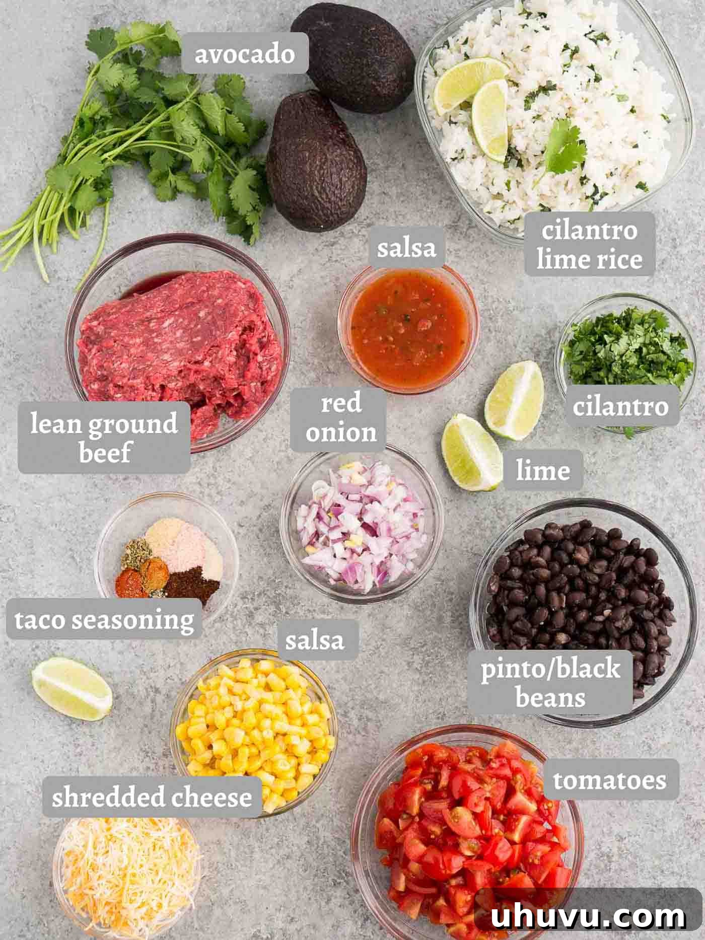 Loaded Taco Bowl 4 A vibrant selection of ingredients for taco bowls laid out, including beef, vegetables, rice, and spices.