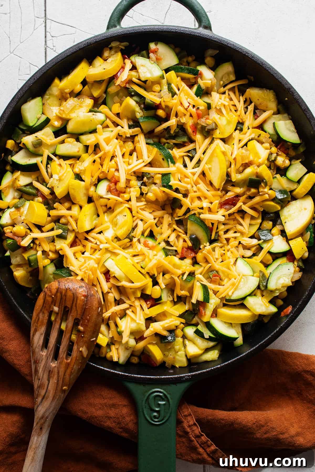 Garden Squash Medley 6 Shredded cheese being mixed into a skillet for a calabacitas recipe.