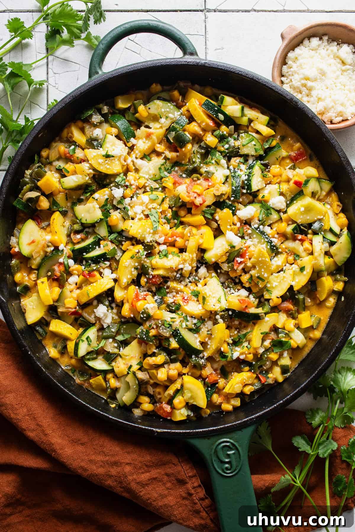 Garden Squash Medley 7 Calabacitas in a skillet topped with cotija cheese and cilantro.