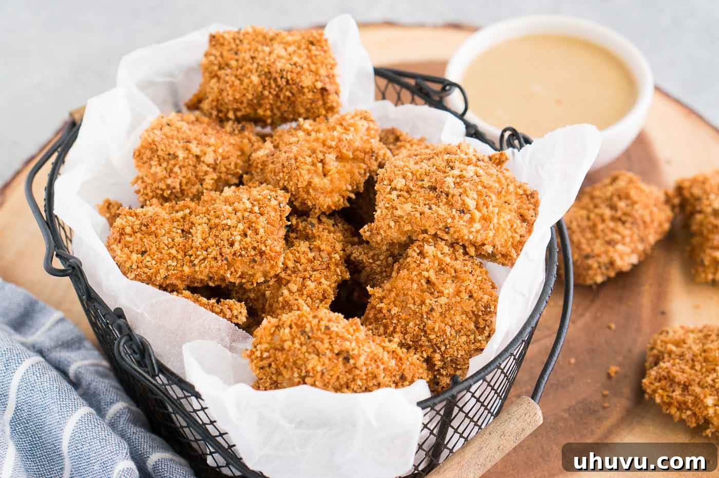 Crispy Homemade Chicken Nuggets 3 chicken nuggets in a basket served with honey mustard sauce for dipping