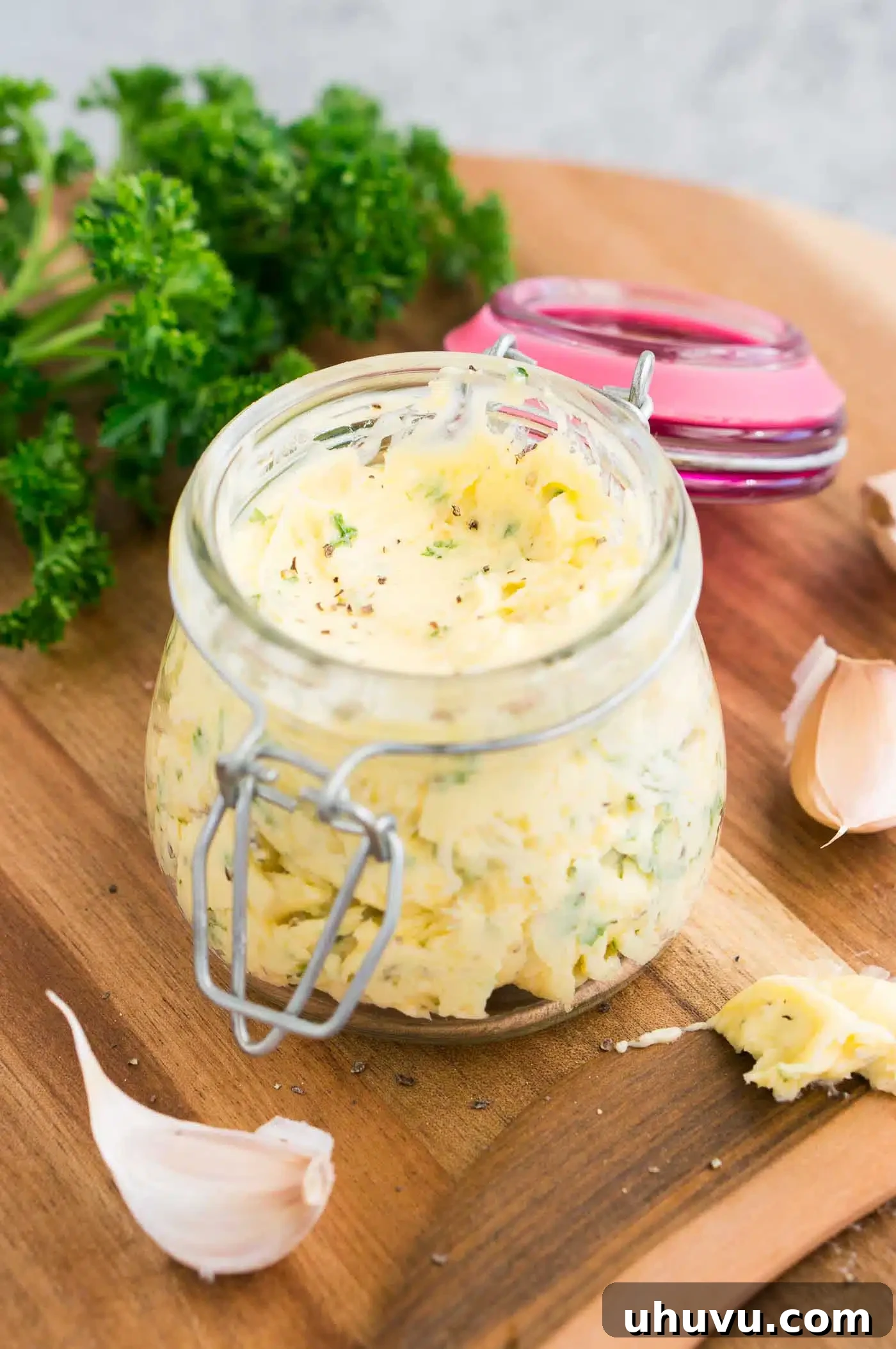 Garlic Gold 7 A charming image of butter infused with garlic and herbs, presented in a clear glass jar.