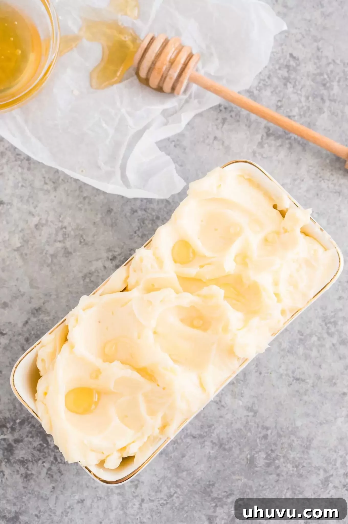 A bowl of creamy honey butter with a spoon, ready to be served or stored