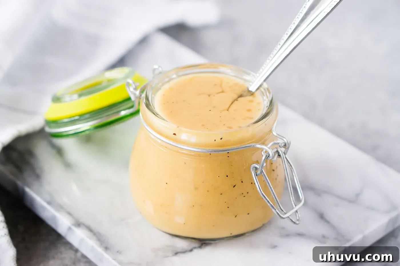 Homemade honey mustard salad dressing in a glass jar, ready to be served.
