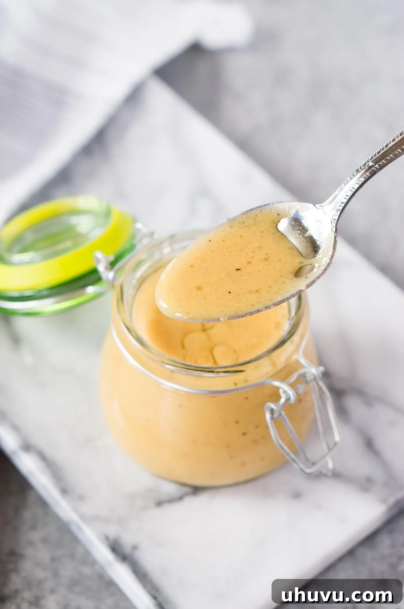 Creamy homemade salad dressing with honey mustard drizzled over fresh greens in a bowl, showcasing its appeal.