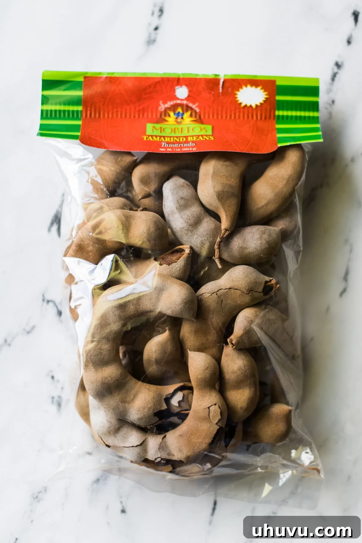 Tamarind Unveiled 3 A collection of tamarind pods neatly arranged in a rustic bag, ready for culinary use.