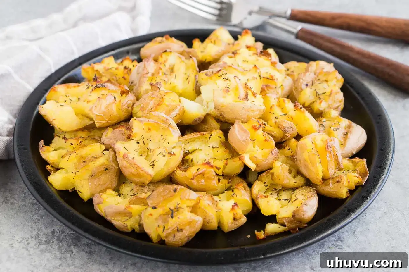 Crispy Crushed Potatoes 3 Crispy smashed potatoes served on a black plate