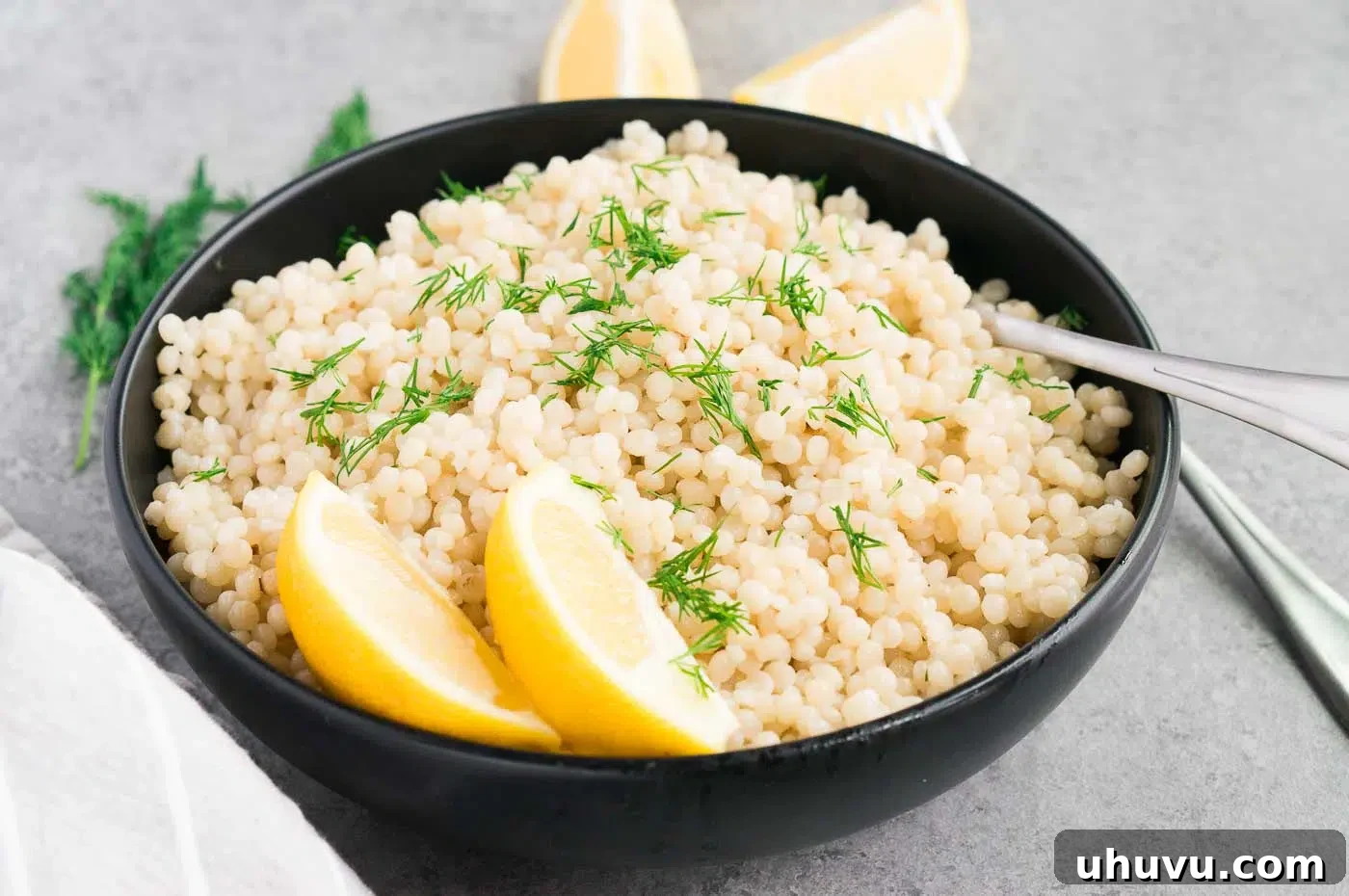 Close up image of fluffy pearl couscous in a bowl.