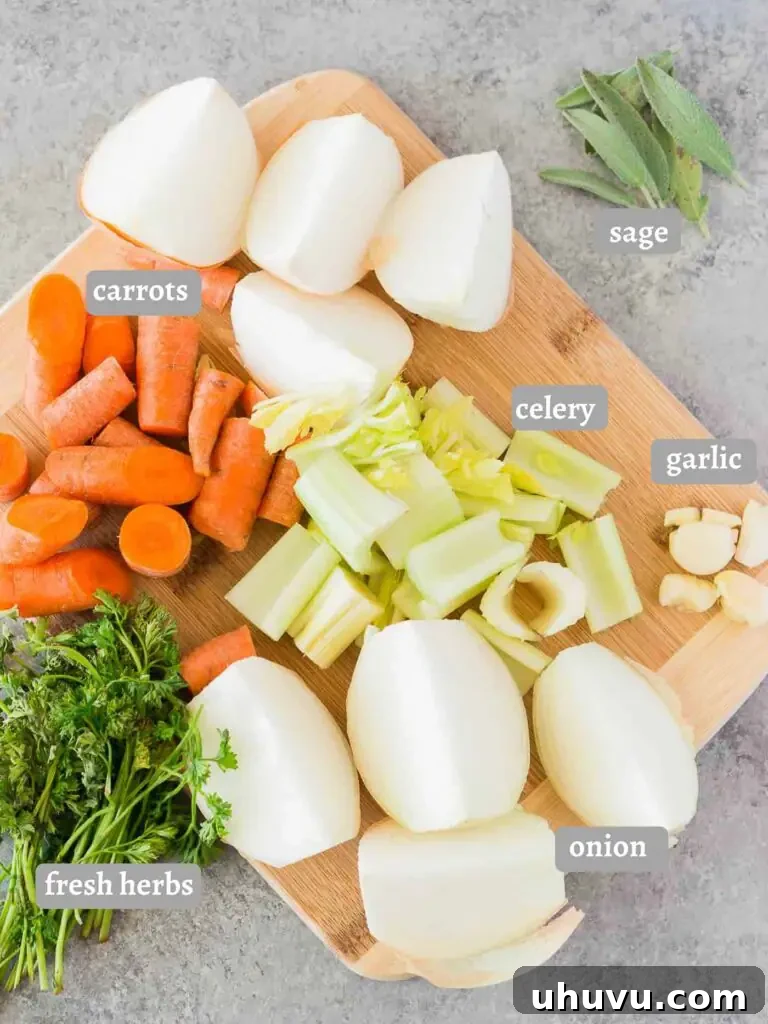 Assortment of fresh vegetables and herbs for making turkey stock, including carrots, onions, celery, and rosemary