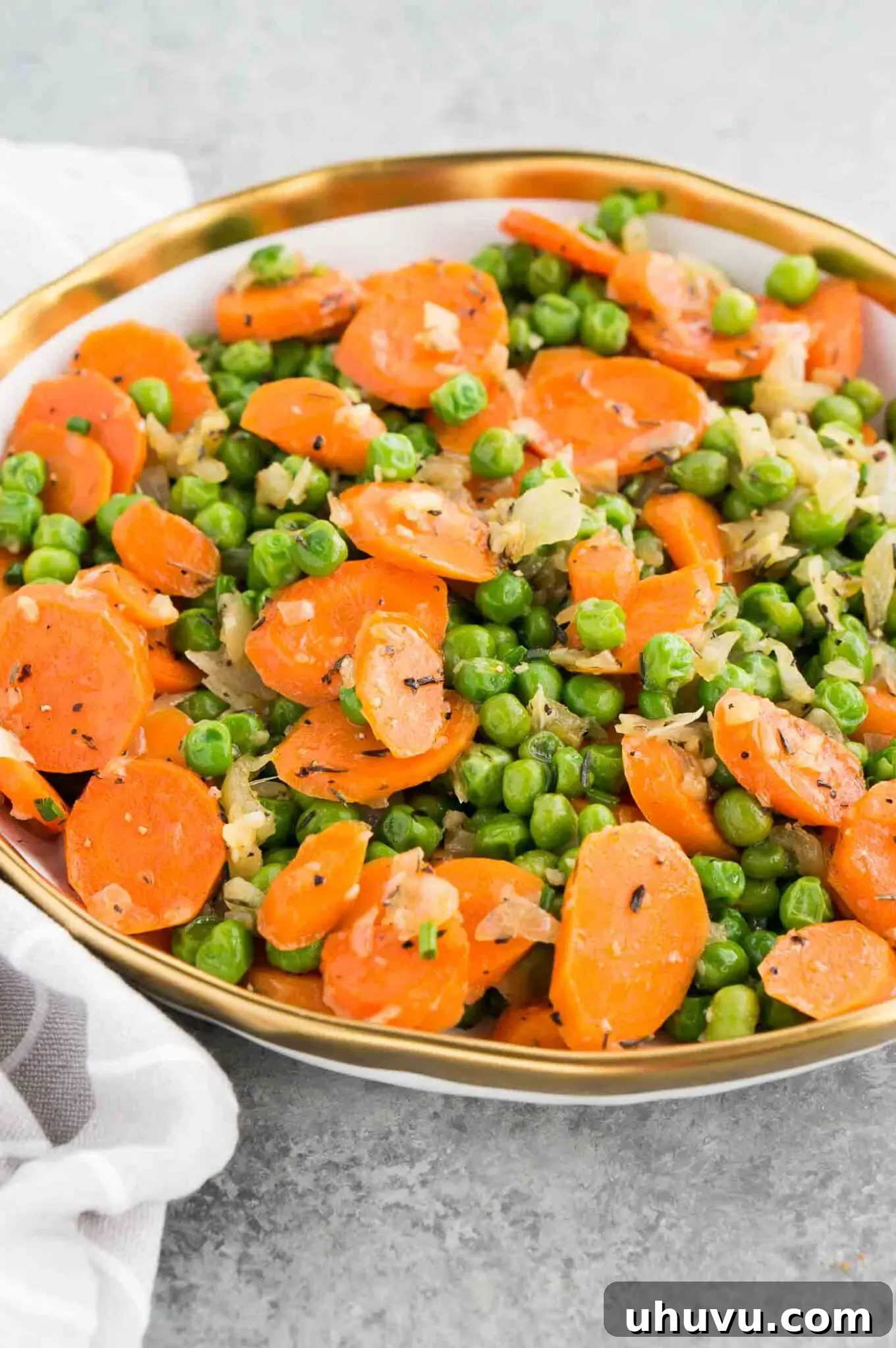 vegetarian side dish with carrots onions and peas in a bowl