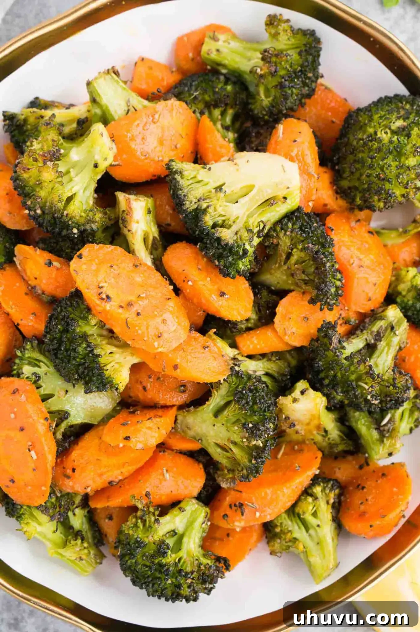 close up image of roasted carrots and broccoli in a bowl