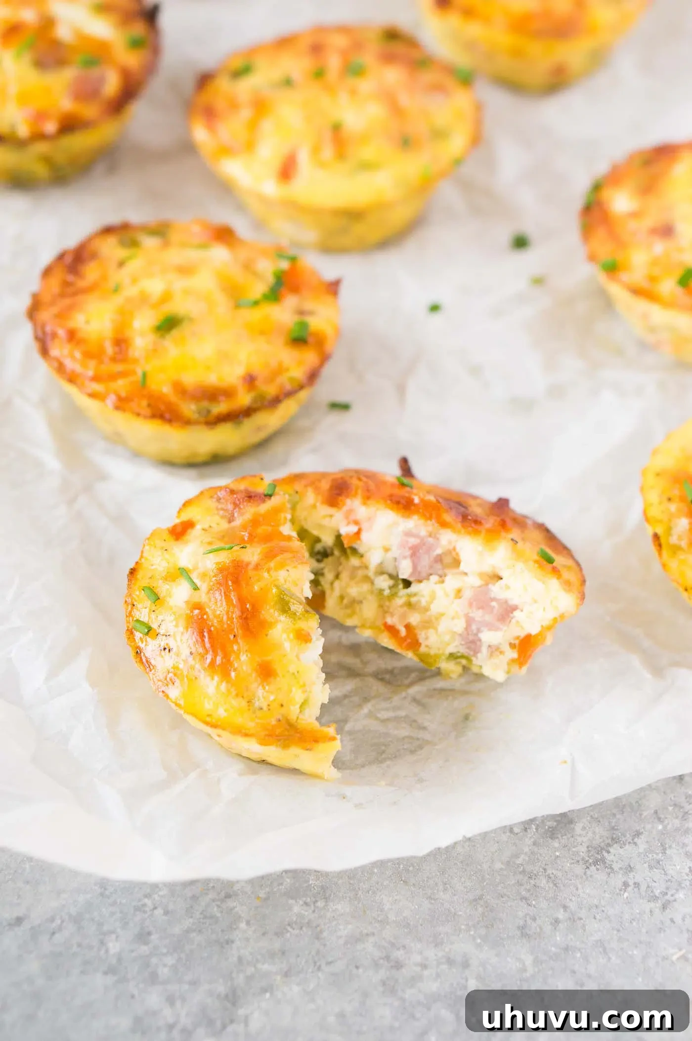 Breakfast egg cup sliced in half, revealing the flavorful ham and cheese filling