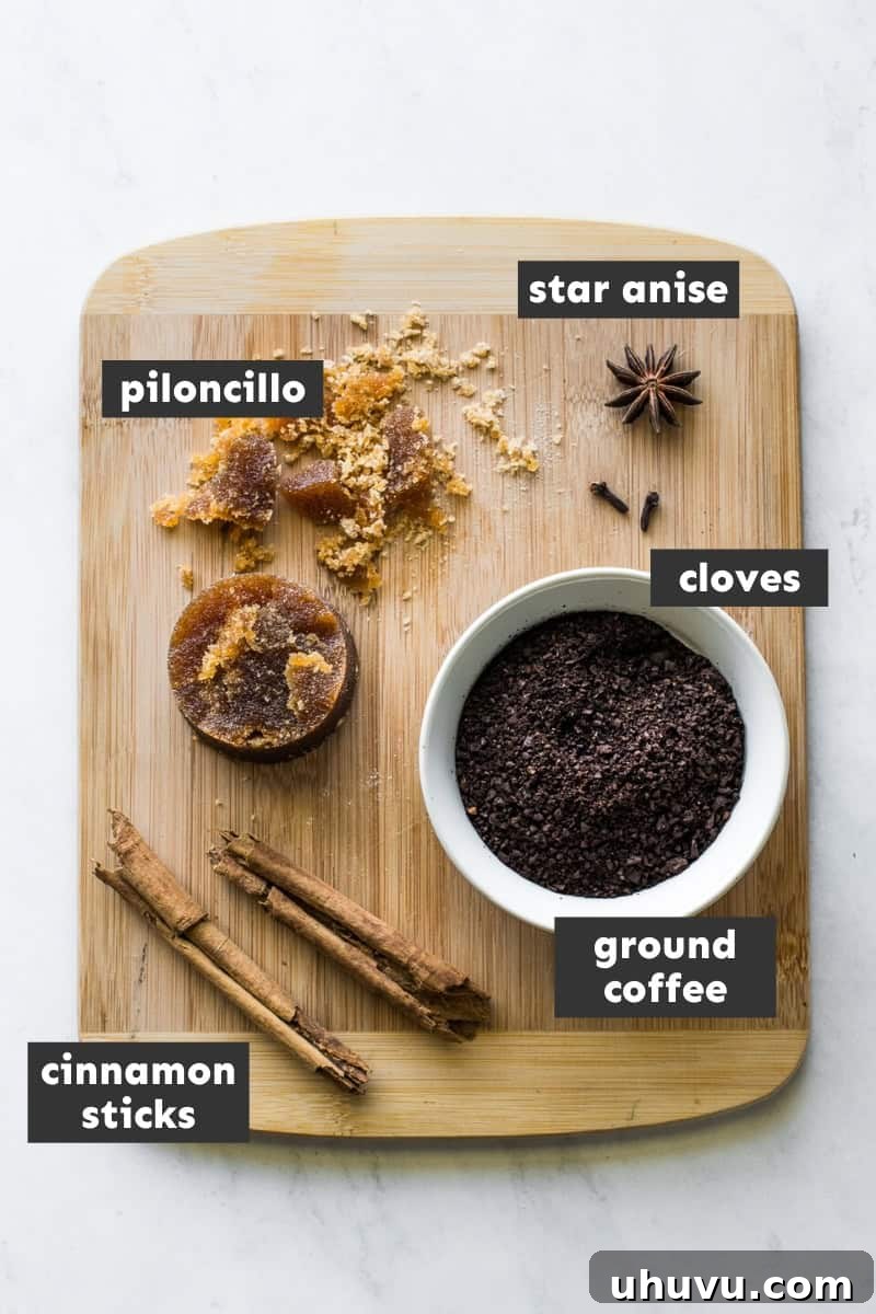 Spiced Olla Coffee 4 Key ingredients for Café de Olla, including piloncillo, cinnamon sticks, cloves, star anise, and ground coffee, arranged on a rustic cutting board.