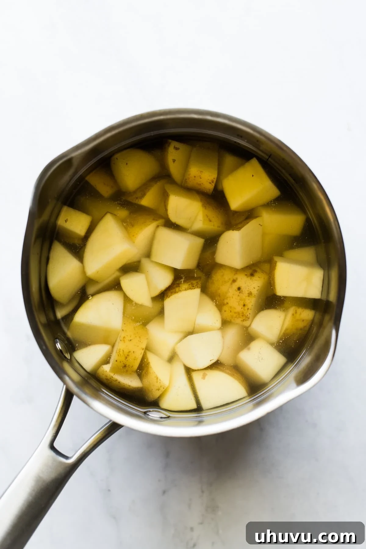 Sizzling Chorizo Potatoes 3 Potatoes cooking in a small saucepan.