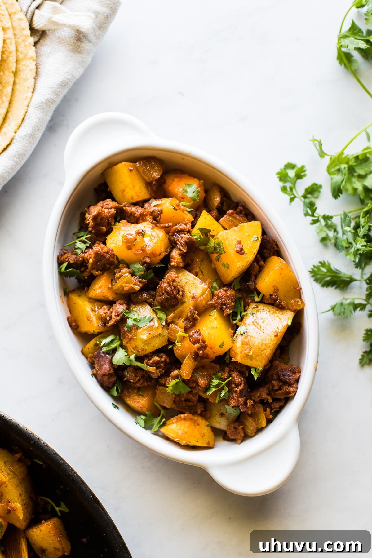 Sizzling Chorizo Potatoes 6 Papas con chorizo in a bowl topped with fresh cilantro.