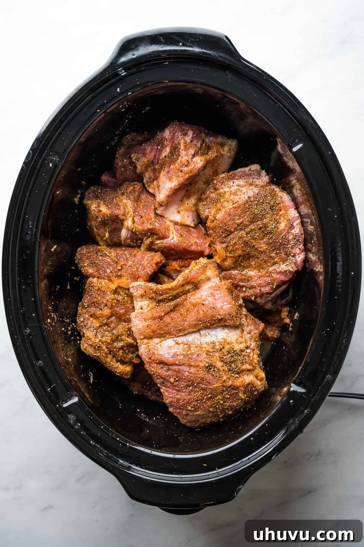 Slow-Cooked Pork Perfection 5 Seasoned pork shoulder nestled in a slow cooker with fresh lime and orange juice, ready for the slow cooking process.