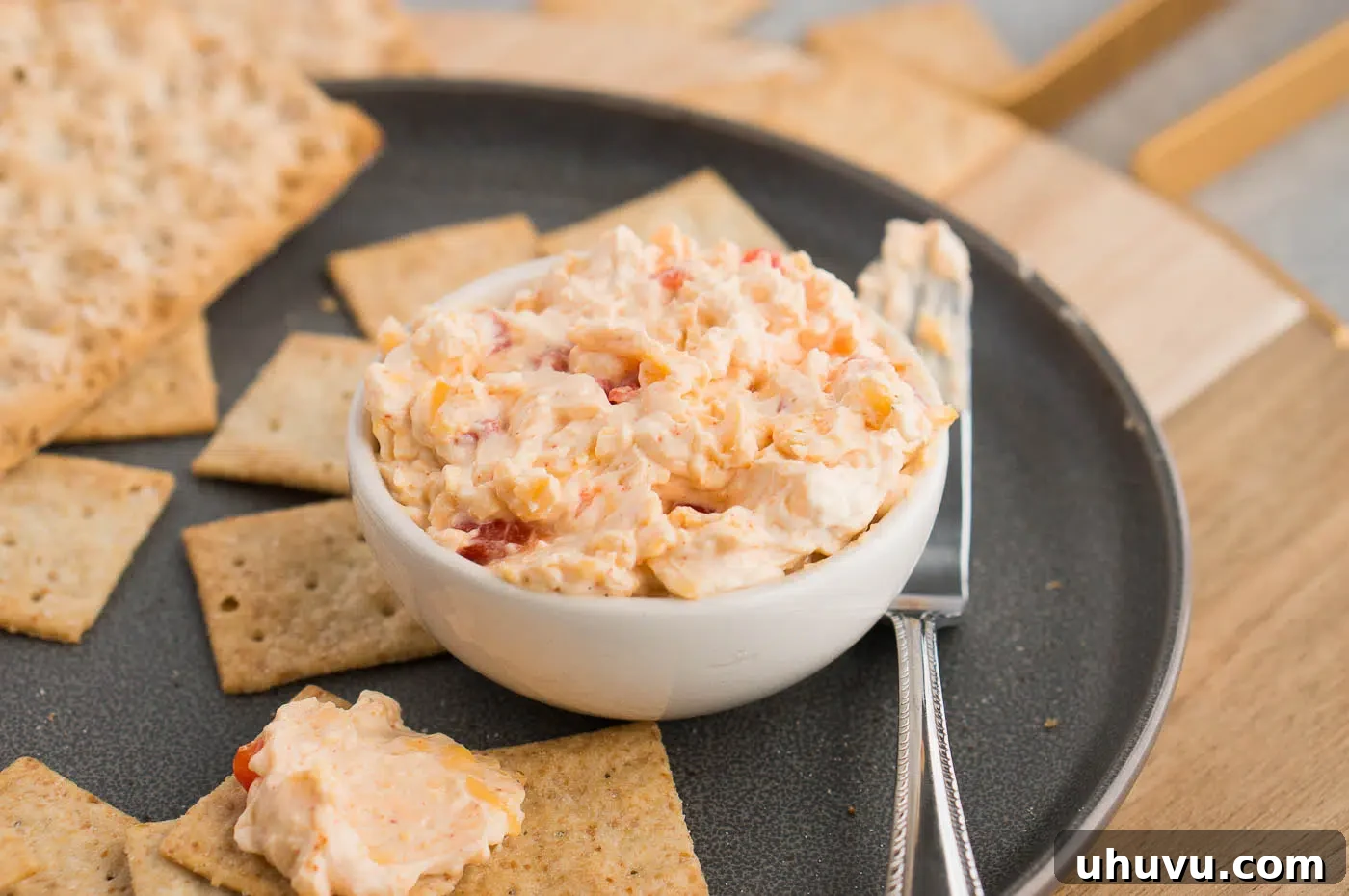 Pimento dip in a decorative bowl surrounded by a variety of crackers, ready for serving.