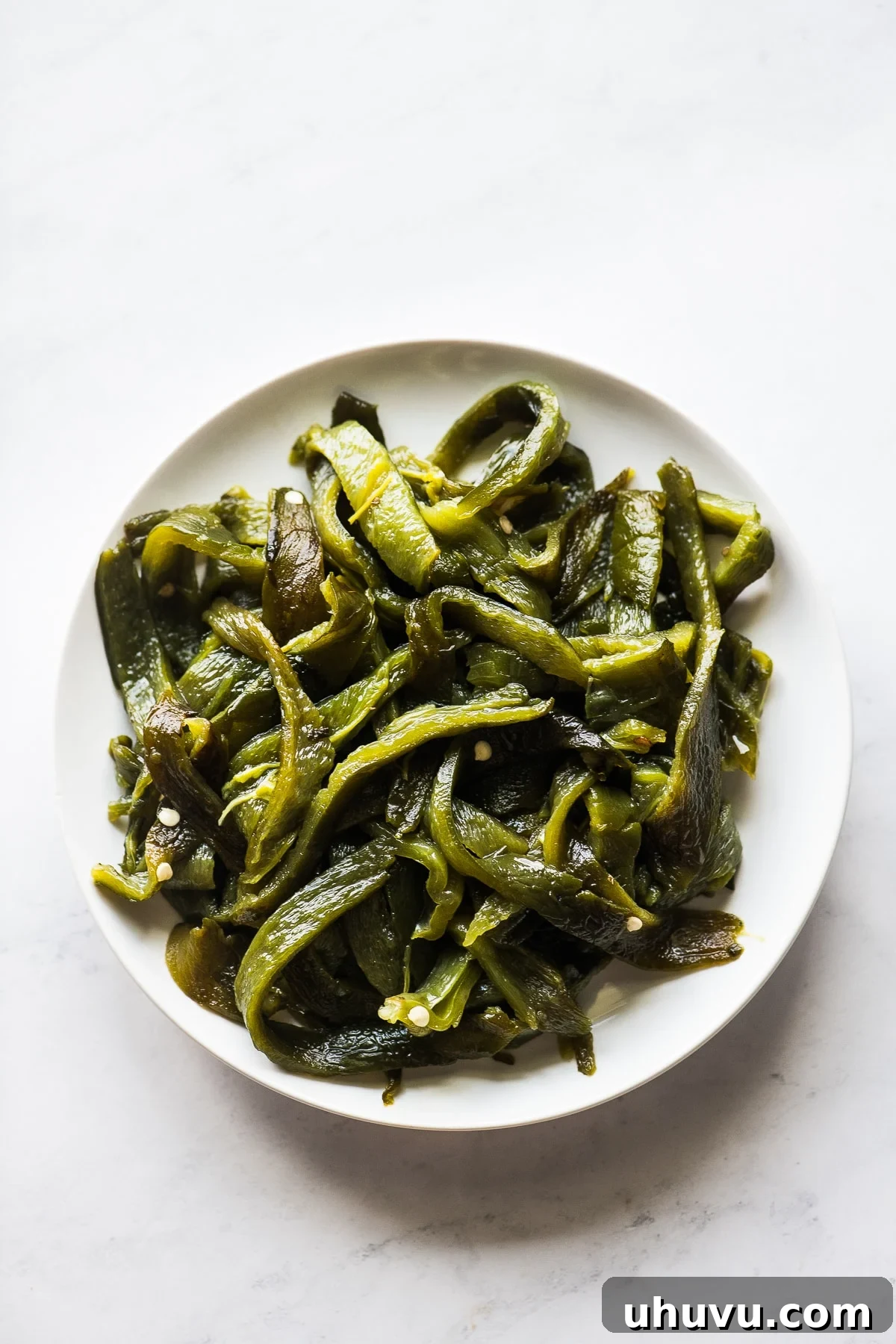 Peeled and sliced roasted poblano pepper strips ready for the skillet.