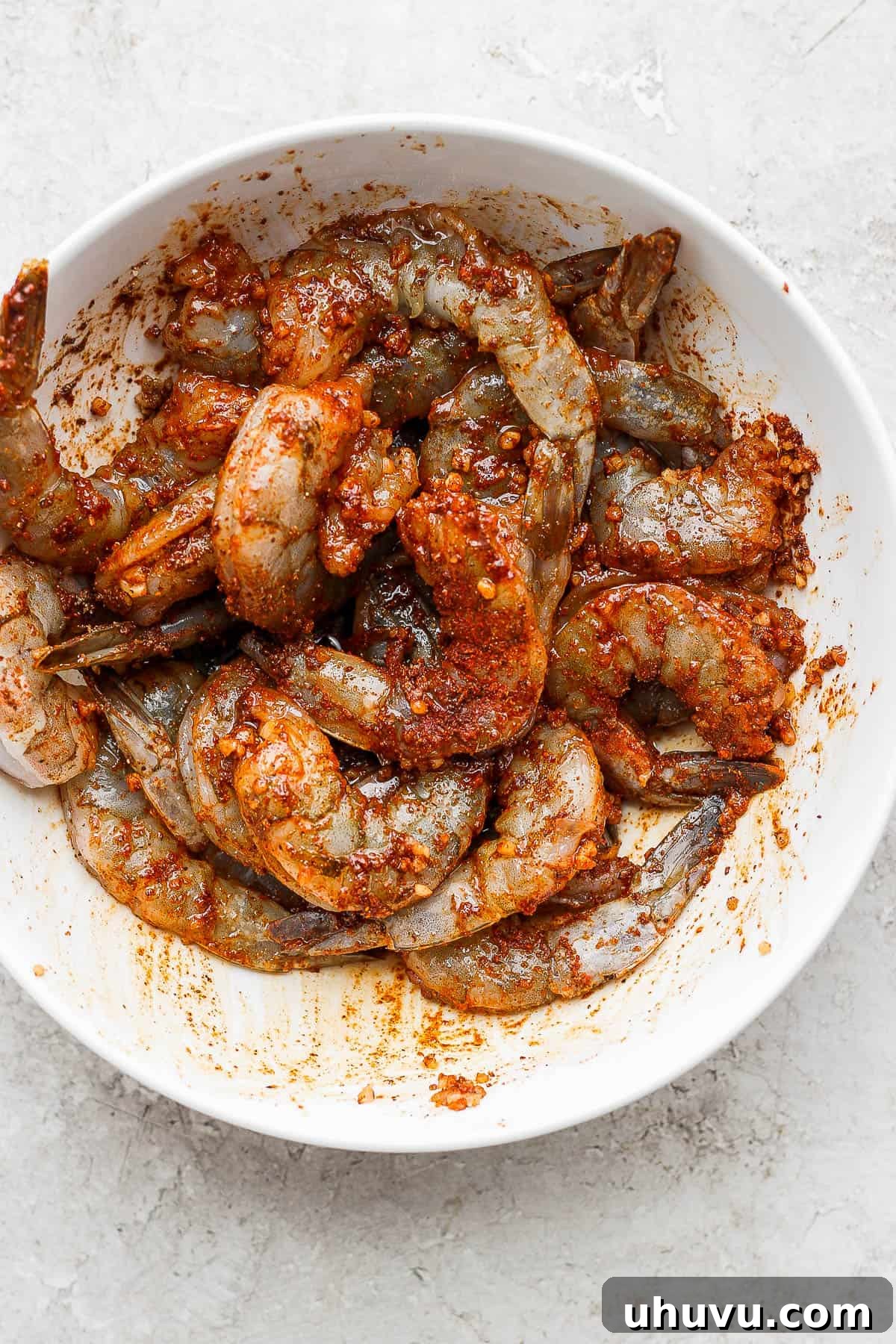 Vibrant Lime Shrimp Fajitas 4 Raw shrimp coated generously with homemade fajita seasoning in a mixing bowl, ready for cooking.