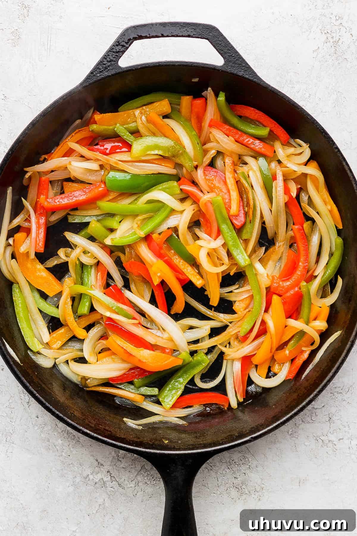 Vibrant Lime Shrimp Fajitas 5 Sautéed and caramelized bell peppers and onions in a hot cast-iron skillet, softened and fragrant, forming the base of the fajita filling.