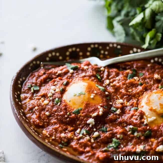 Huevos ahogados in a red salsa.