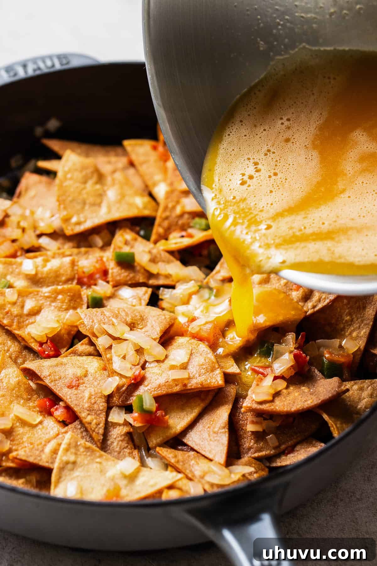 Combine the sautéed vegetables with the fried tortilla chips, then pour in the eggs.