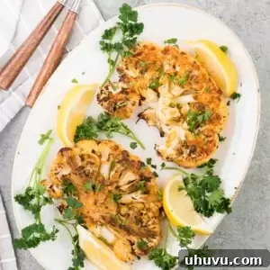 oven roasted cauliflower steaks with lemon slices on a platter