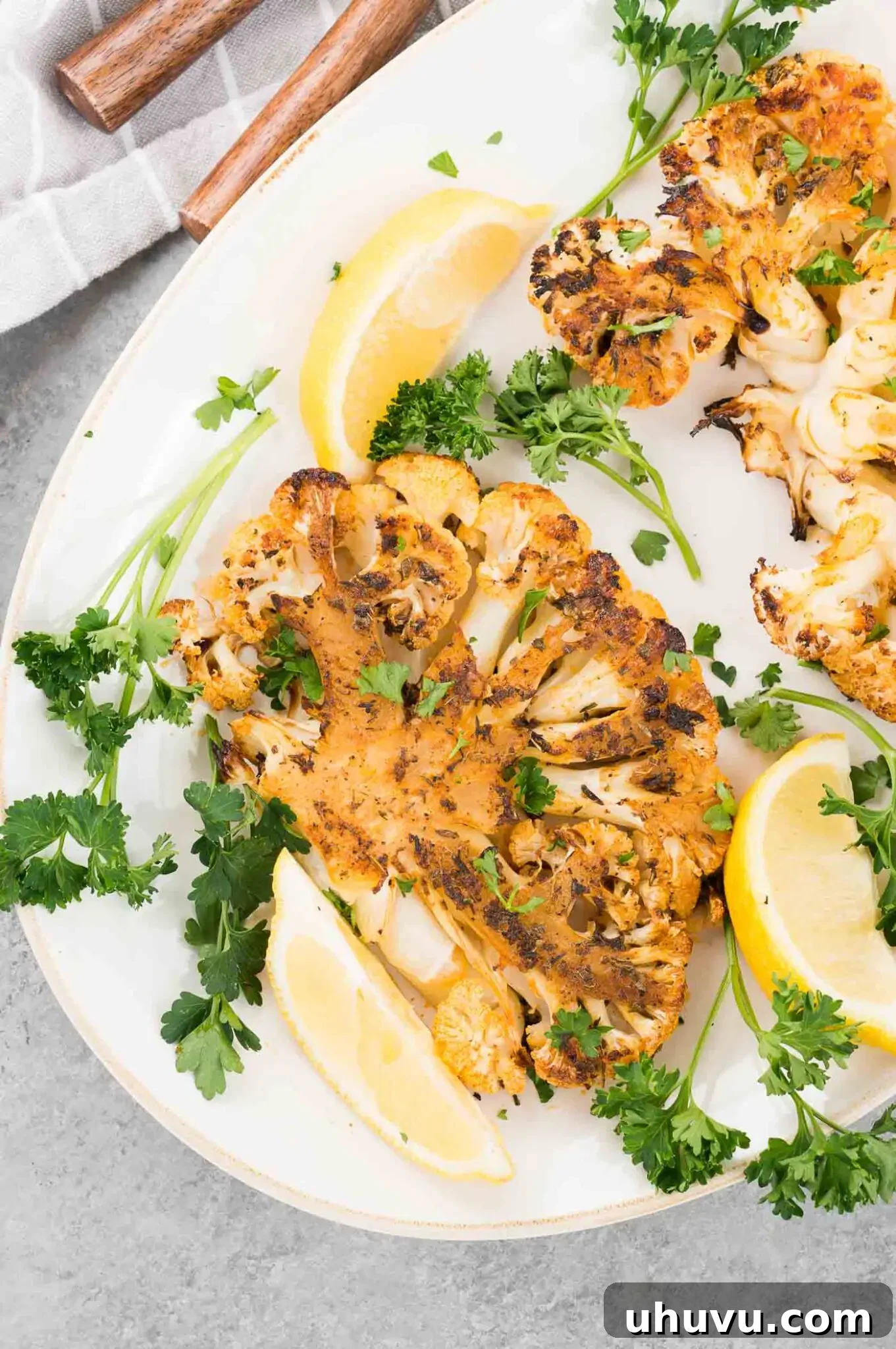 cauliflower slices and lemon wedges on a plate