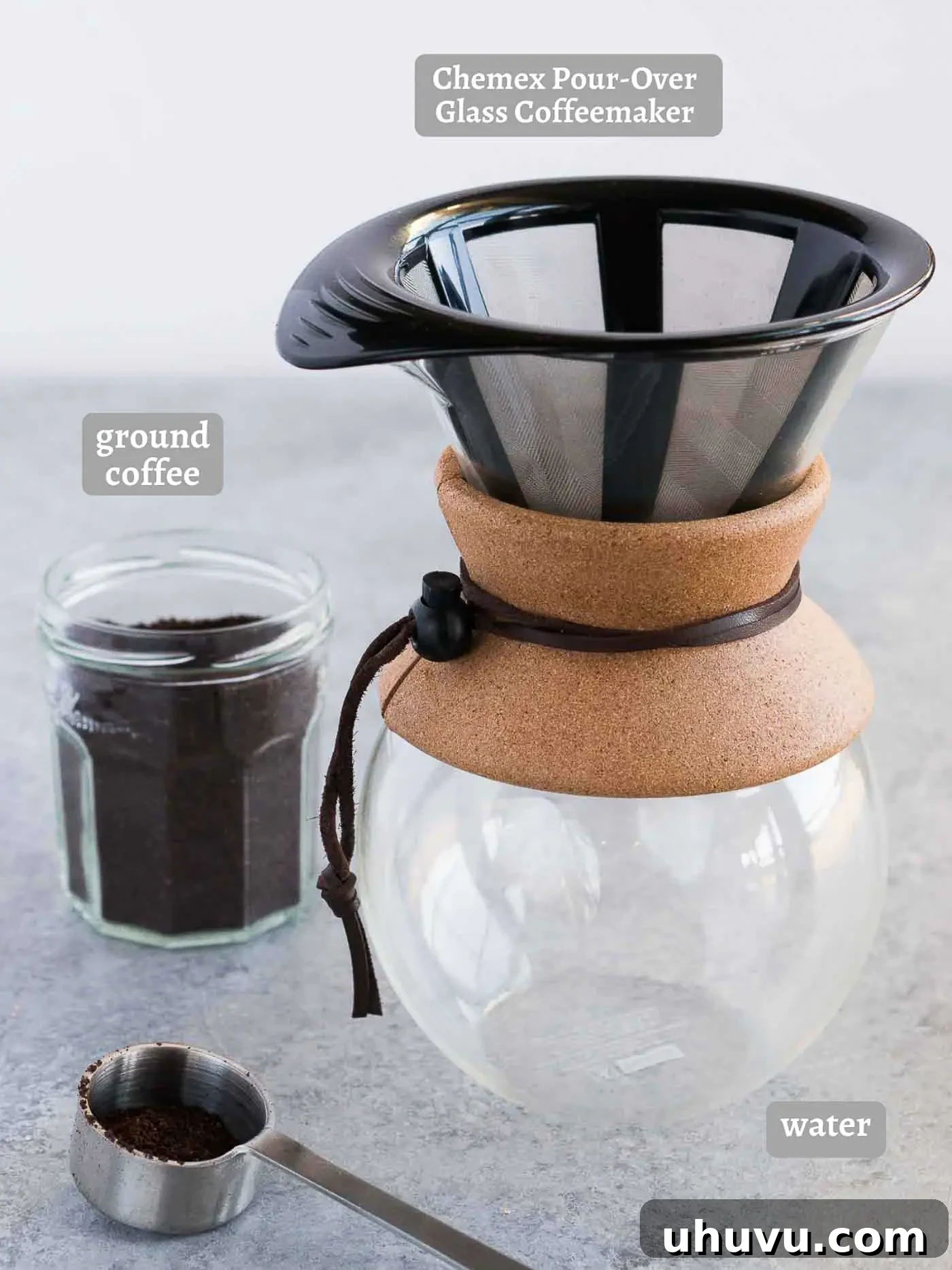 coffee and chemex on a board with fresh coffee beans and filtered water
