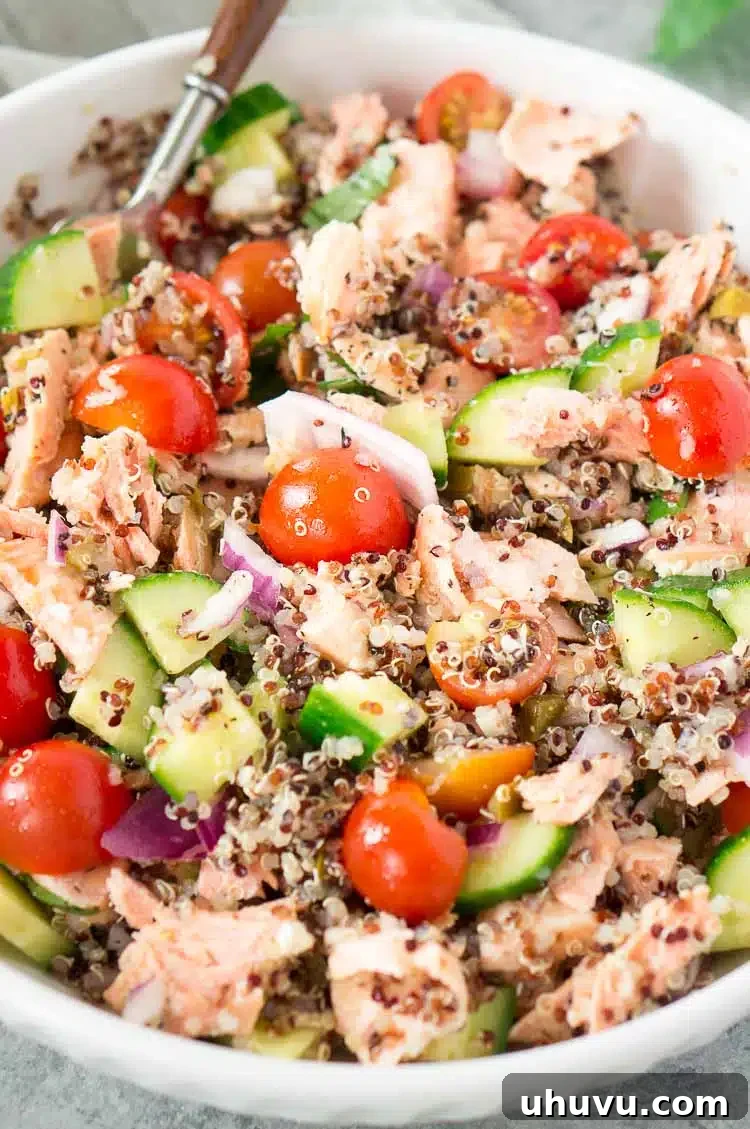 Quinoa Salmon Salad in a white bowl with a fork, ready to eat