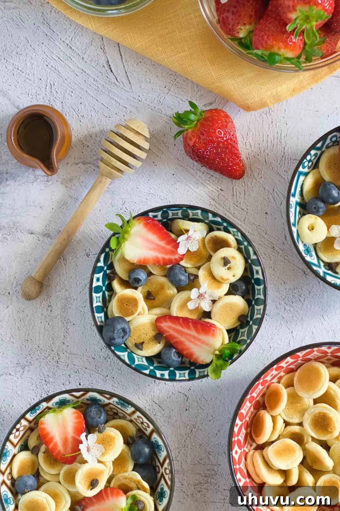 Overhead shot of pancake cereal in a bowl with various berry toppings.